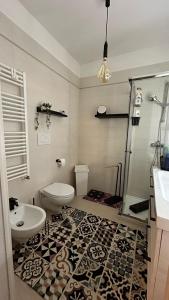 La salle de bains est pourvue de toilettes, d'un lavabo et d'une douche. dans l'établissement creedhouse in the historic center, à Casamassima
