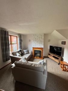 a living room with two couches and a fireplace at Runaway Cottage, Whitby in Whitby