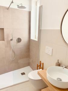 a bathroom with a shower and a toilet and a sink at Camere Assúd in Leuca