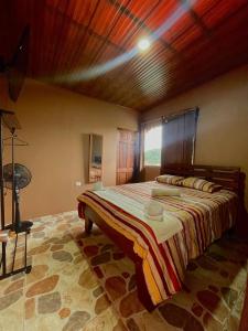 - une chambre avec un grand lit et un plafond en bois dans l'établissement Dreams Lodge Orosi, à Cartago