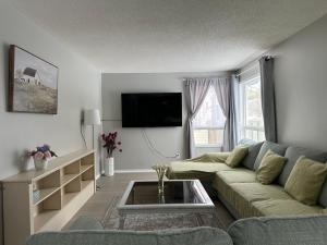 sala de estar con sofá y TV en Lake Simicoe town cottage near Innisfil Beach Park, en Innisfil