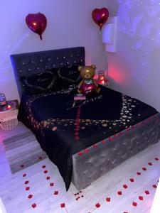 een slaapkamer met een teddybeer op een bed bij Sparadisejacuzzi in Éragny