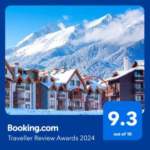 a hotel with a snow covered mountain in the background at Penthouse Harriet Bansko in Bansko