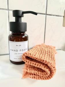 a bottle of hand formula next to a towel at Gemütliches Cottage am Fuße des Schwarzwaldes in Kandern