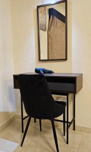 uma secretária preta com uma cadeira e um espelho em studio em Agia Napa