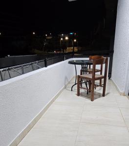 uma mesa e uma cadeira numa varanda à noite em studio em Agia Napa