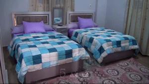two beds sitting next to each other in a bedroom at Loulouat Al Reef in Kafr ʼakīm