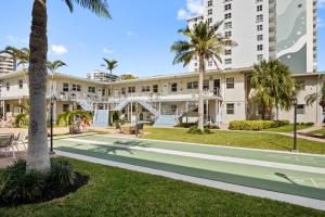 un gran edificio blanco con palmeras y una pasarela en Serene Seaside Escape- 1BR Bliss, en Fort Lauderdale