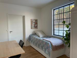 a bedroom with a bed and a table and a window at A Place to Call Home in Skellefteå