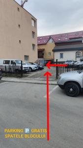 une flèche rouge pointant vers une voiture garée sur un parking dans l'établissement StudioConfort, à Braşov