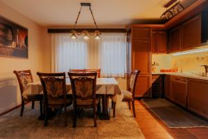 a kitchen with a dining room table and chairs at Sky Villa Brezovice in Brezovica