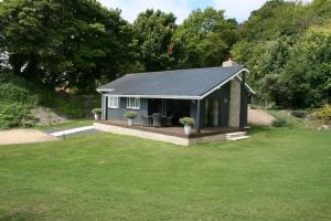 a small house with a deck in a yard at The Cabin in Weymouth