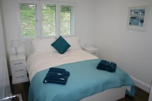 1 dormitorio con 1 cama con 2 toallas en The Cabin 2 bedroom property, en Weymouth