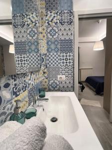 baño con lavabo y azulejos en la pared en Peppe's Home relax apartament the view, en Gragnano