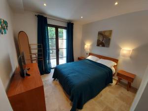 ein Schlafzimmer mit einem Bett und einem großen Fenster in der Unterkunft Villa avec piscine proche mer et saint tropez in Grimaud