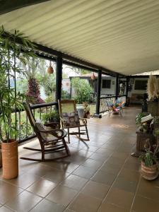 a patio with two chairs and awning with plants at Hostal greenlandomesa in Piedecuesta