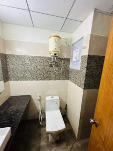 ein kleines Bad mit WC und Waschbecken in der Unterkunft Paramount Golfforeste in Greater Noida