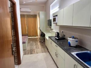 eine Küche mit weißen Schränken und einer Arbeitsplatte in der Unterkunft Paramount Golfforeste in Greater Noida