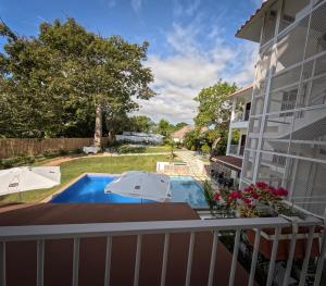 einen Balkon mit Blick auf ein Haus mit Pool in der Unterkunft Hotel Pedasí Nature Paradise in Pedasí Town