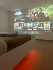 a room with a bed and a large screen at Appartement T2 cosy (aéroport - parc des expo - parc Astérix) in Tremblay En France