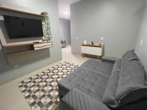 a living room with a couch and a flat screen tv at Casa inteira em Nova Mutum in Nova Mutum