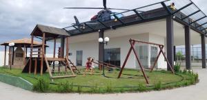 a little girl playing on a playground with a helicopter at Casa do Maro in Santo Amaro