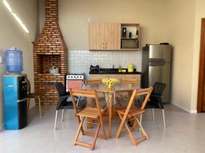 a kitchen with a table and chairs and a refrigerator at Casa do Maro in Santo Amaro