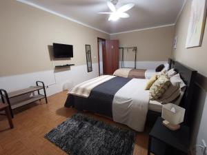 sypialnia z 2 łóżkami i telewizorem z płaskim ekranem w obiekcie Vila Viegas w mieście São Vicente Ferreira