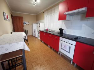 a kitchen with red cabinets and a counter top at Vila Viegas in São Vicente Ferreira