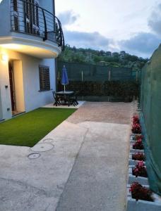un jardín con patio y una mesa con sombrilla en Casa Green en Silvi Marina