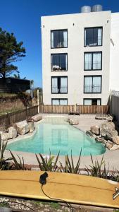 a building with a swimming pool in front of a building at Faro Aparts in Mar del Plata