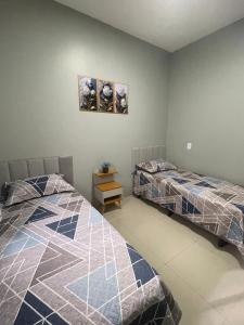 2 nebeneinander sitzende Betten in einem Schlafzimmer in der Unterkunft Casa inteira em Nova Mutum in Nova Mutum