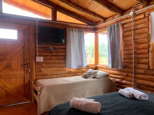 1 dormitorio con 2 camas en una cabaña de madera en Cabañas Punta Arena en San Pedro