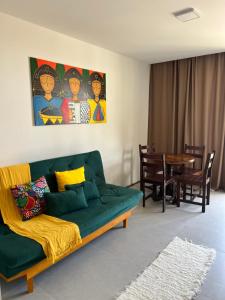 a living room with a green couch and a table at Beira mar rota dos milagres - Porto de pedras AL in Pôrto de Pedras