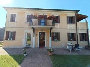 a house with a balcony and a table and chairs at B&B We CaRe Appartamento in Lendinara