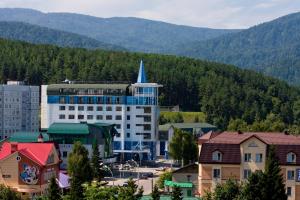 a large building with a blue steeple in a city at Spa-Hotel&Resort Belovodie with Aquapark in Belokurikha