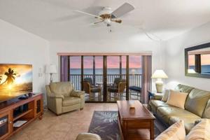ein Wohnzimmer mit einem Sofa und einem Tisch in der Unterkunft Beachfront Condo with Pool and Hot Tub Reflections On The Gulf 504 in Clearwater Beach