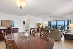 ein Wohnzimmer mit einem Esstisch und einer Küche in der Unterkunft Beachfront Condo with Pool and Hot Tub Reflections On The Gulf 504 in Clearwater Beach