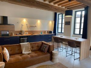 salon z brązową kanapą i stołem w obiekcie Maison Authentique « Bleue Nuits » w mieście Nuits-Saint-Georges