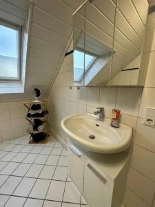 a bathroom with a sink and a mirror at Stilvoll eingerichtetes Ferienhaus in ruhiger Lage in Bremerhaven +12 photos