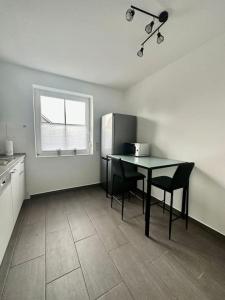 eine Küche mit einem Tisch und einem Kühlschrank in der Unterkunft Stilvoll eingerichtetes Ferienhaus in ruhiger Lage in Bremerhaven