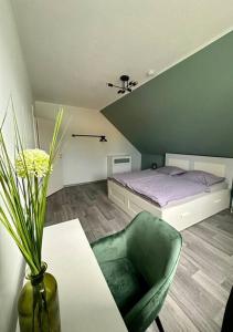 1 dormitorio con 1 cama, 1 mesa y 1 silla verde en Stilvoll eingerichtetes Ferienhaus in ruhiger Lage en Bremerhaven