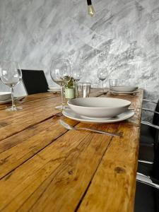 un tavolo in legno con un piatto e bicchieri da vino sopra di Stilvoll eingerichtetes Ferienhaus in ruhiger Lage a Bremerhaven