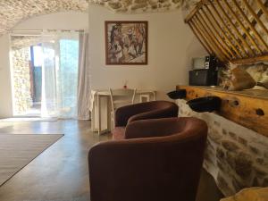 a living room with three chairs and a table at Gîtes 2 adultes dans un mas charme et calme assuré in Servas