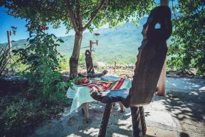 eine Person, die an einem Tisch vor einem Baum sitzt in der Unterkunft Robinson Haus Ivan in Makarska