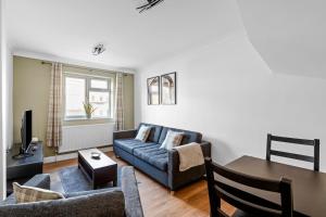 a living room with a couch and a table at Cosy 2 Bedroom Flat in East Ham, Close to Excel in London