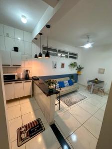 Apartamento no coração de BH! في بيلو هوريزونتي: مطبخ وغرفة معيشة مع طاولة وأريكة