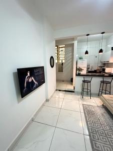 sala de estar y cocina con TV en la pared en Apartamento no coração de BH!, en Belo Horizonte