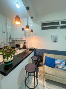 cocina y sala de estar con 2 taburetes y barra en Apartamento no coração de BH!, en Belo Horizonte