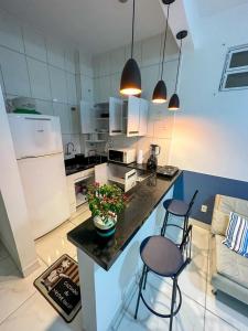 una cocina con una isla con 2 sillas y una encimera en Apartamento no coração de BH!, en Belo Horizonte